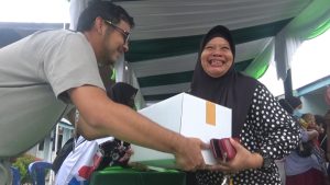 Warga sumringah usai menerima paket sembako dengan harga sangat murah di Pasar Murah PHR yang dilaksanakan di halaman Masjid Dakwah, Rumbai, Pekanbaru.